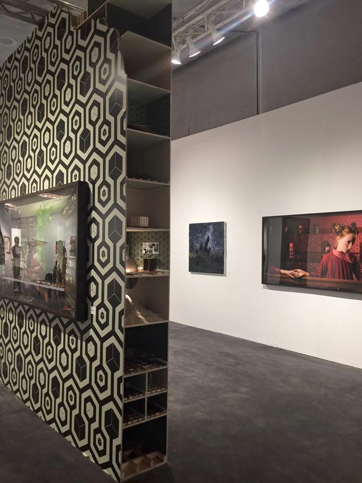 Installation view of Laetitia Soulier's artwork at Miami Art Basel, featuring geometric wallpaper and framed photographs.