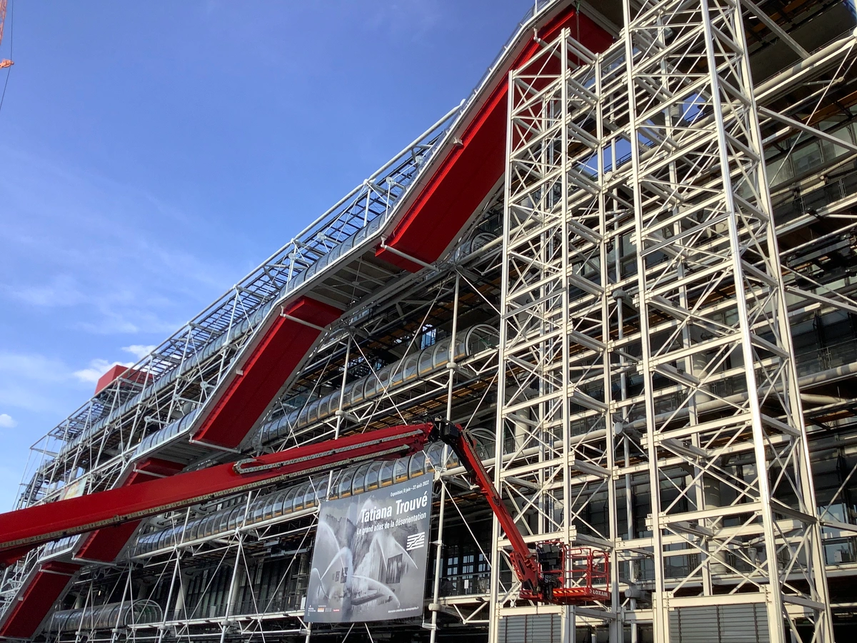 The striking, modern facade of the Centre Pompidou in Paris, featuring its iconic external pipes, escalators, and structural elements.