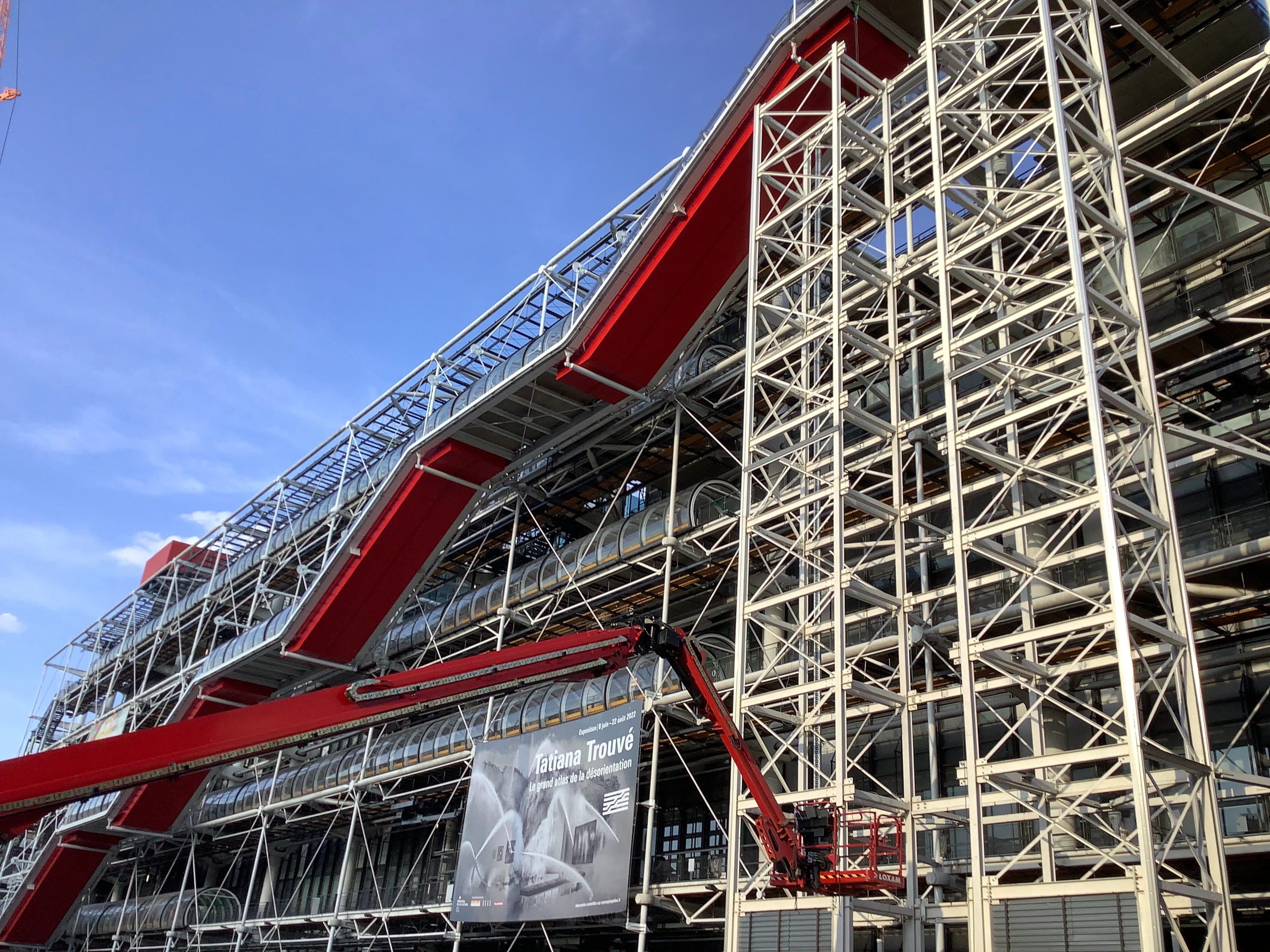 The striking, modern facade of the Centre Pompidou in Paris, featuring its iconic external pipes, escalators, and structural elements.