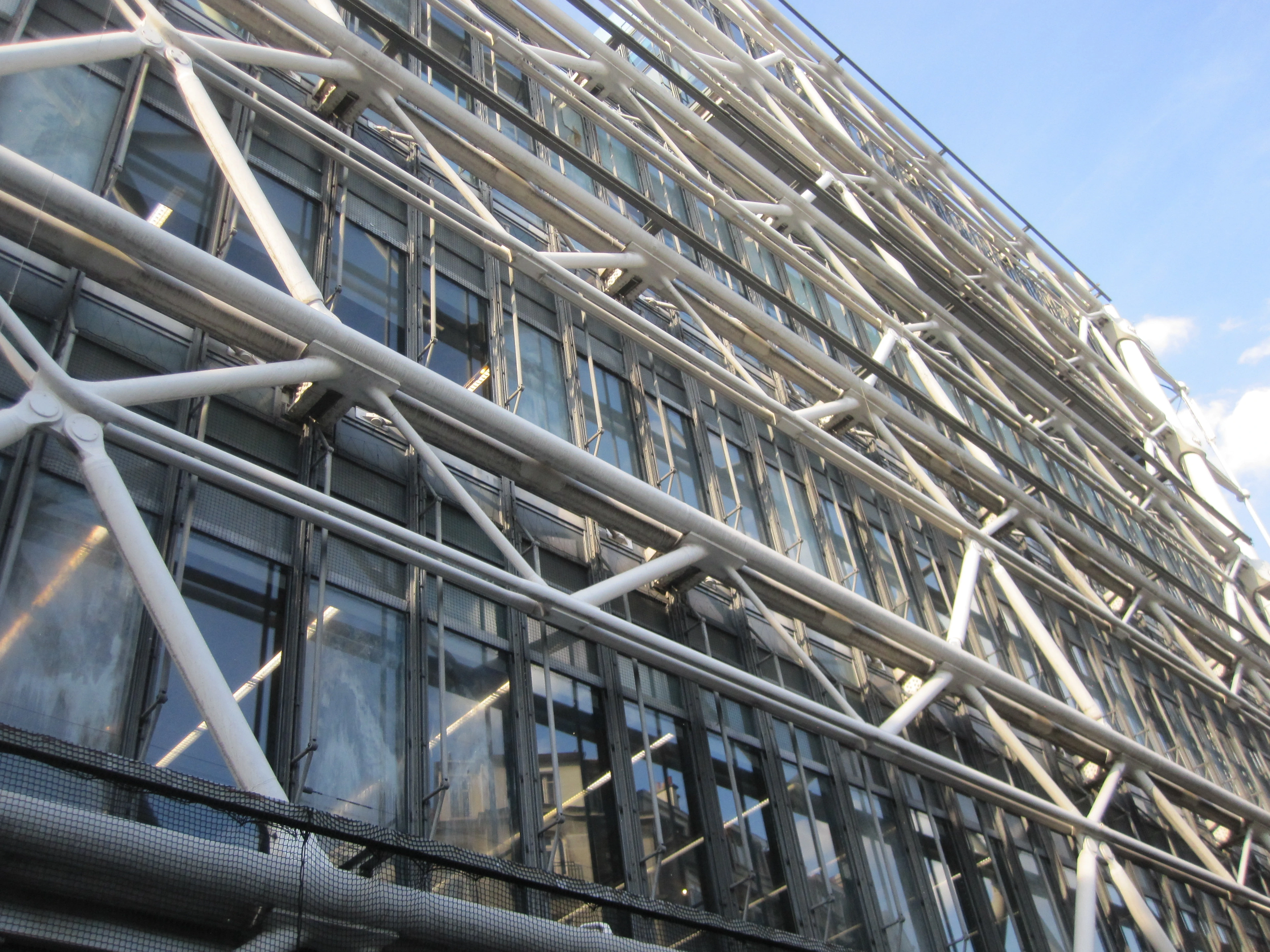 Detail of the external structure and glass facade of the Centre Pompidou in Paris, showcasing its unique architectural design.