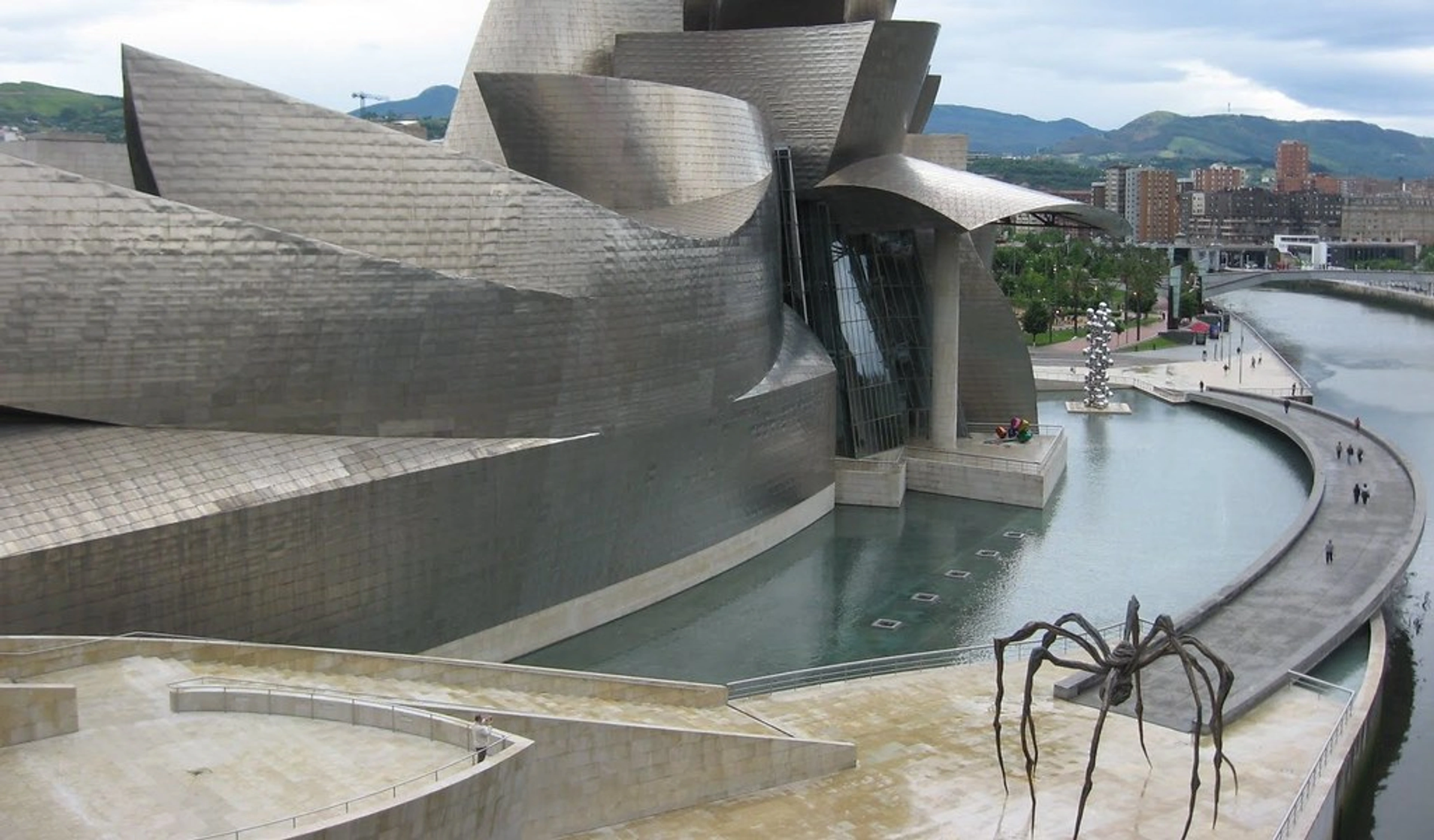Guggenheim Museum Bilbao exterior with Jeff Koons' "Puppy" sculpture and the Nervión River.