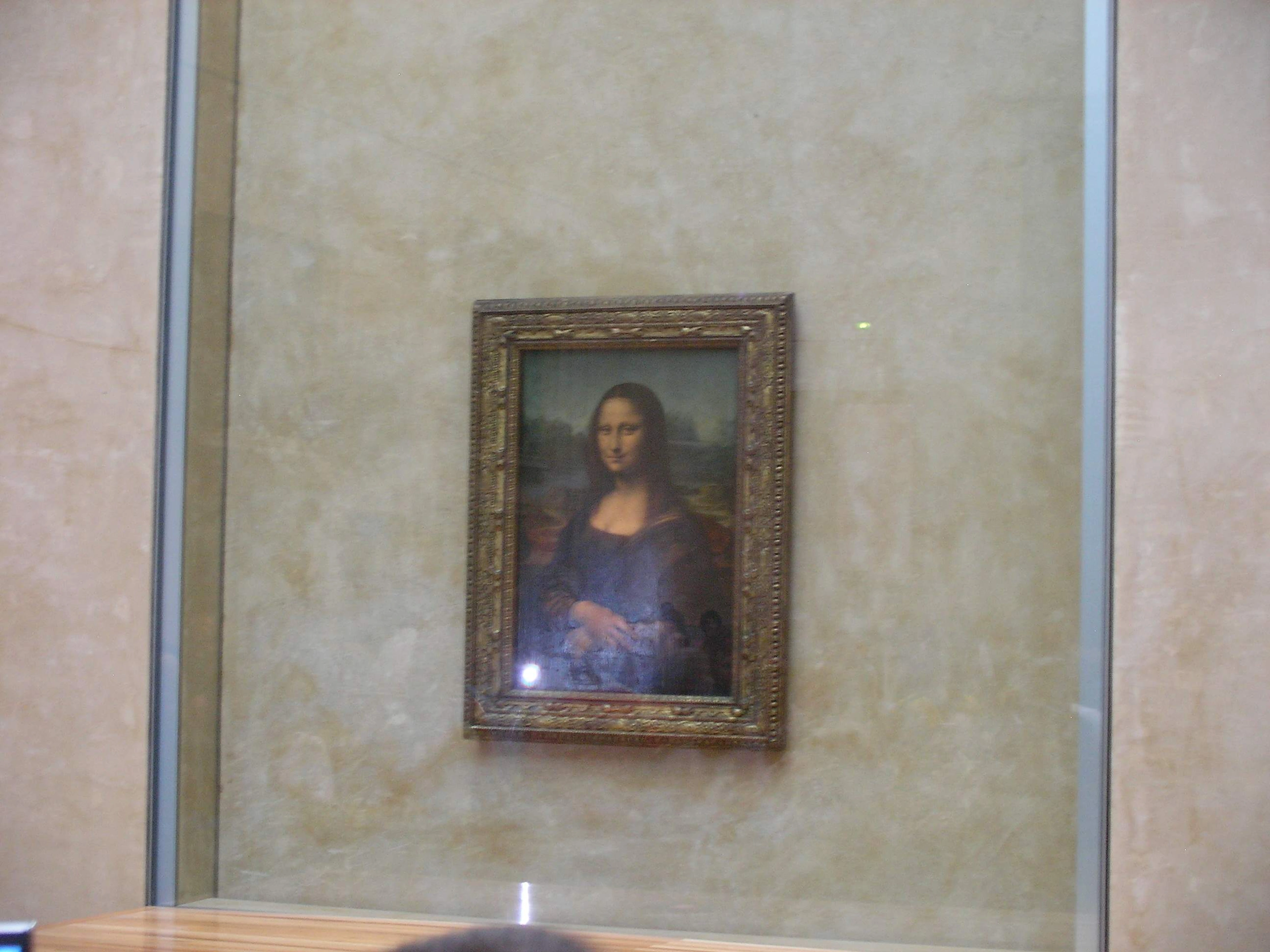 The Mona Lisa painting by Leonardo da Vinci, displayed at the Louvre Museum.