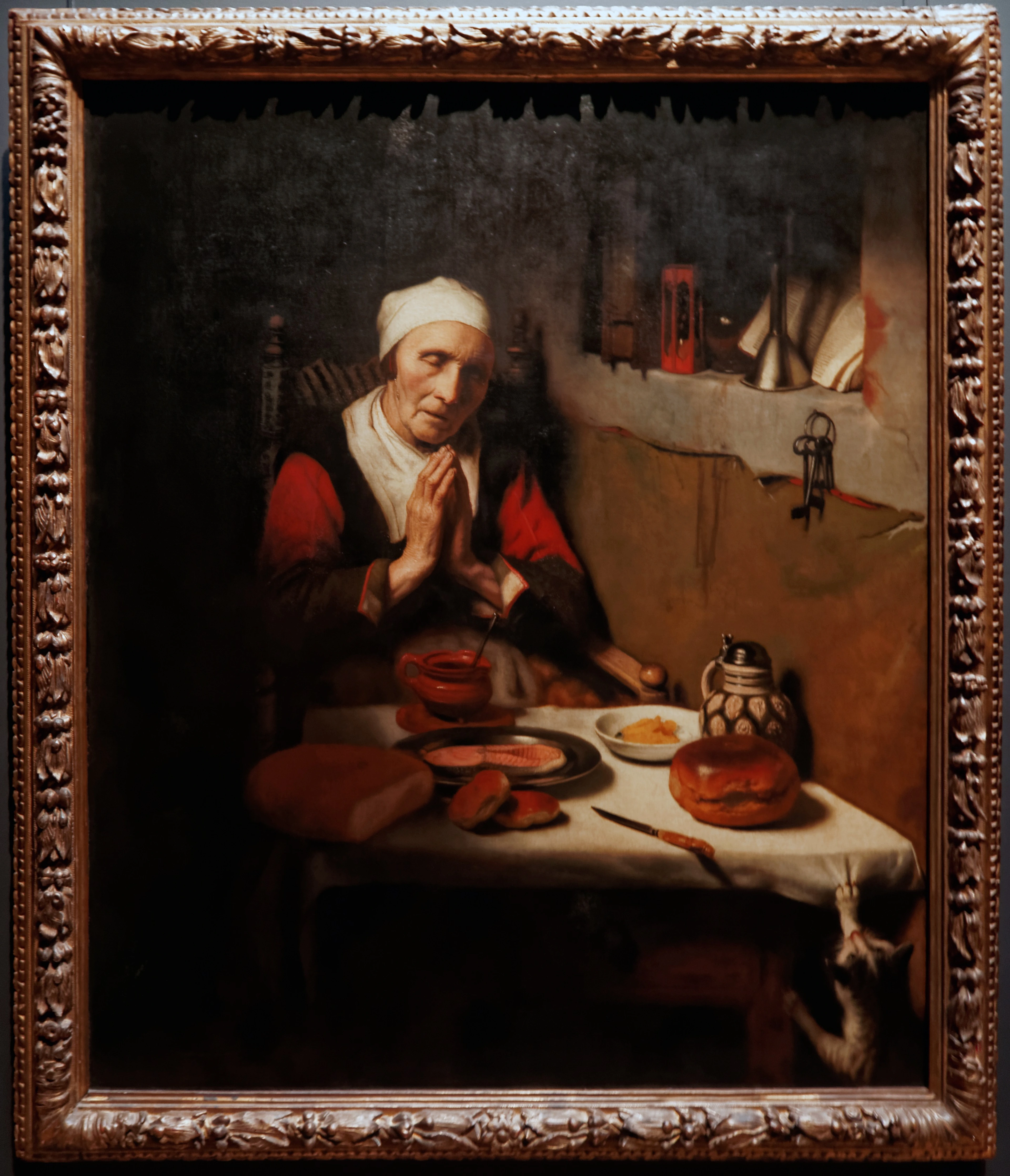 Old woman praying at a table in the Rijksmuseum, Amsterdam