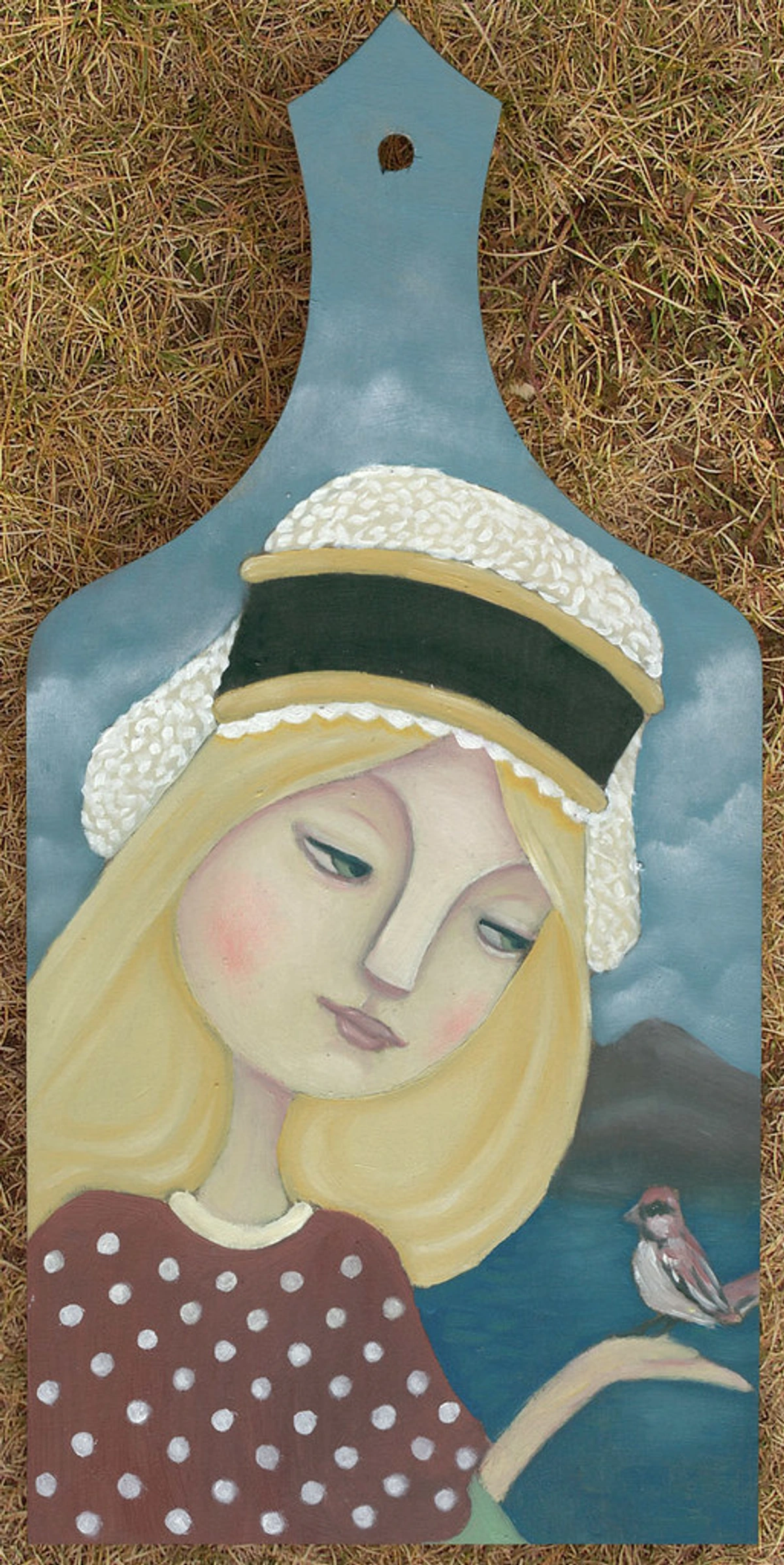Cute little bird on a hand-painted wooden cutting board with a portrait of a girl.