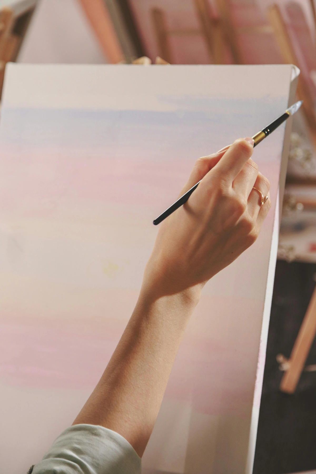 Woman hand painting on canvas with brush, personal touch in art, vibrant colors, artistic close-up