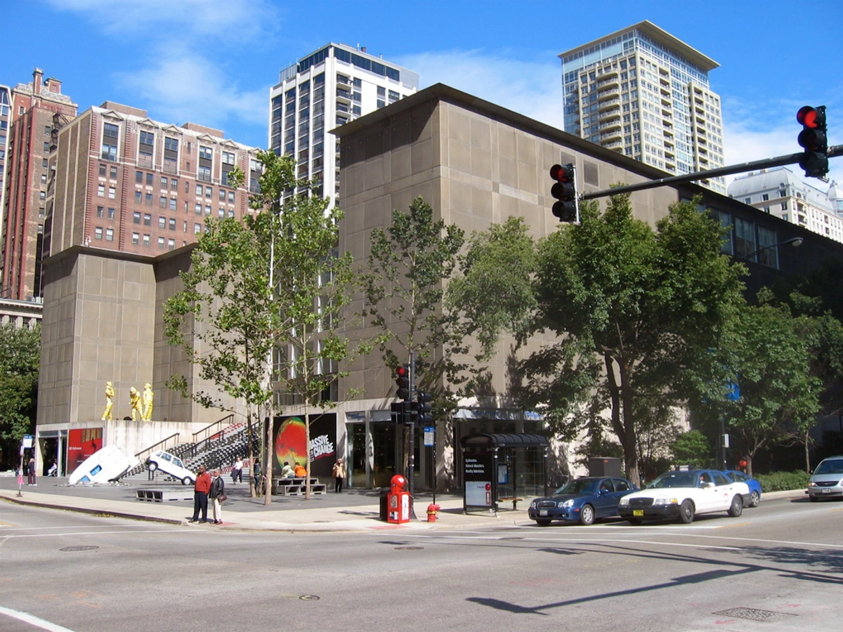 The Museum of Contemporary Art Chicago (MCA) with its modern architecture and outdoor art installations, including sculptures and a car partially submerged in stairs.