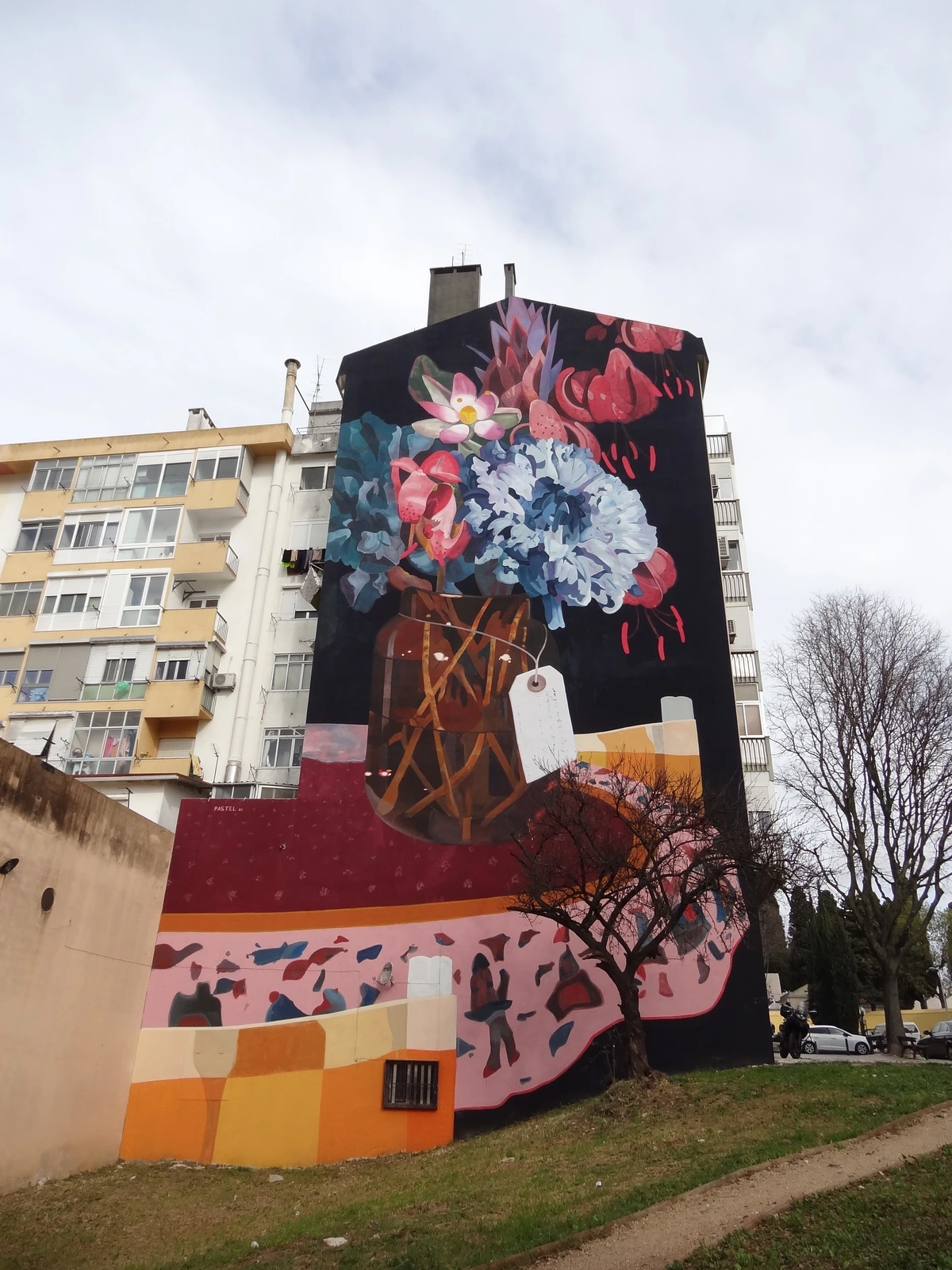 Vibrant mural of a floral bouquet in a vase by artist Pastel, titled Lḗthē, on a building facade in Lisbon, Portugal.
