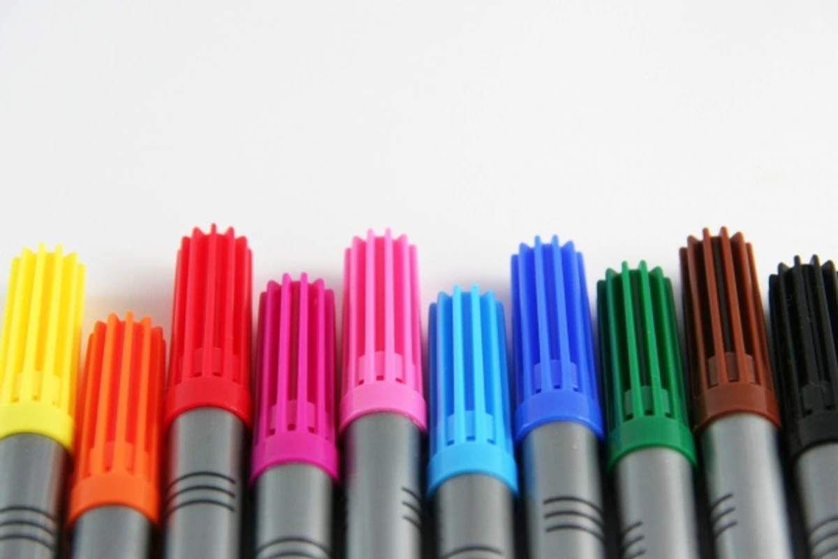 A row of colorful alcohol-based markers for artists, displayed against a white background.