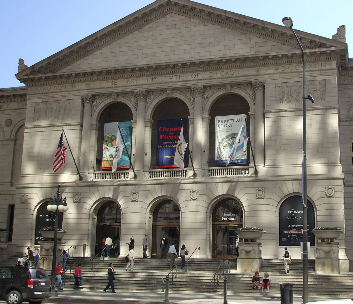 The grand facade of the Art Institute of Chicago, featuring neoclassical architecture, arched entrances, and banners for current exhibitions.