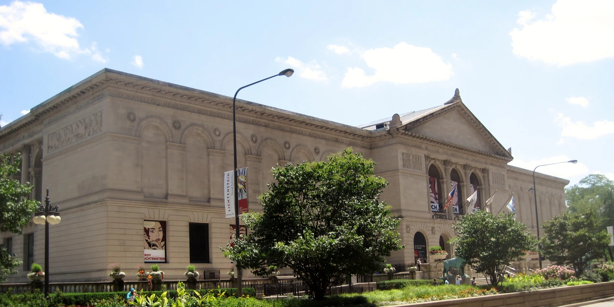 The Art Institute of Chicago, a renowned art museum with classical architecture, featuring banners for a Roy Lichtenstein exhibition.