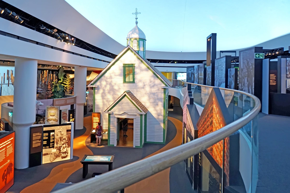 Interior view of the Canadian History Hall at the Canadian Museum of History, featuring a reconstructed church and various historical exhibits.