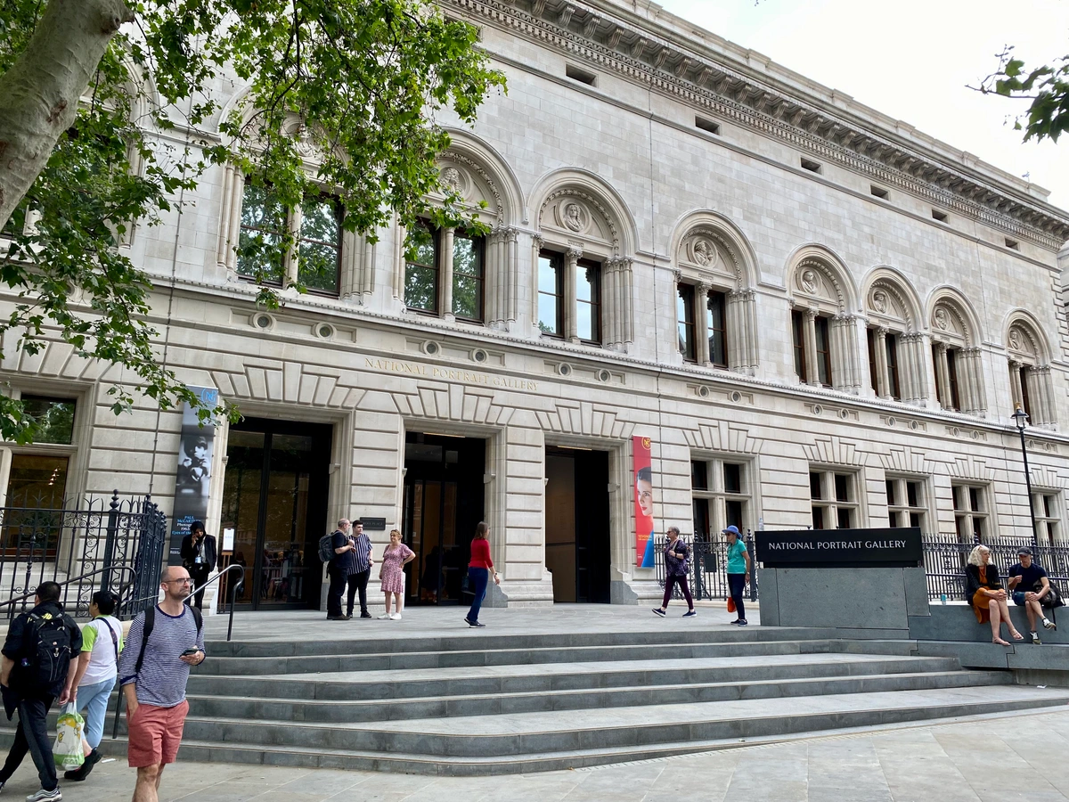 The grand stone facade of the National Portrait Gallery in London, featuring its main entrance with wide steps and architectural details.