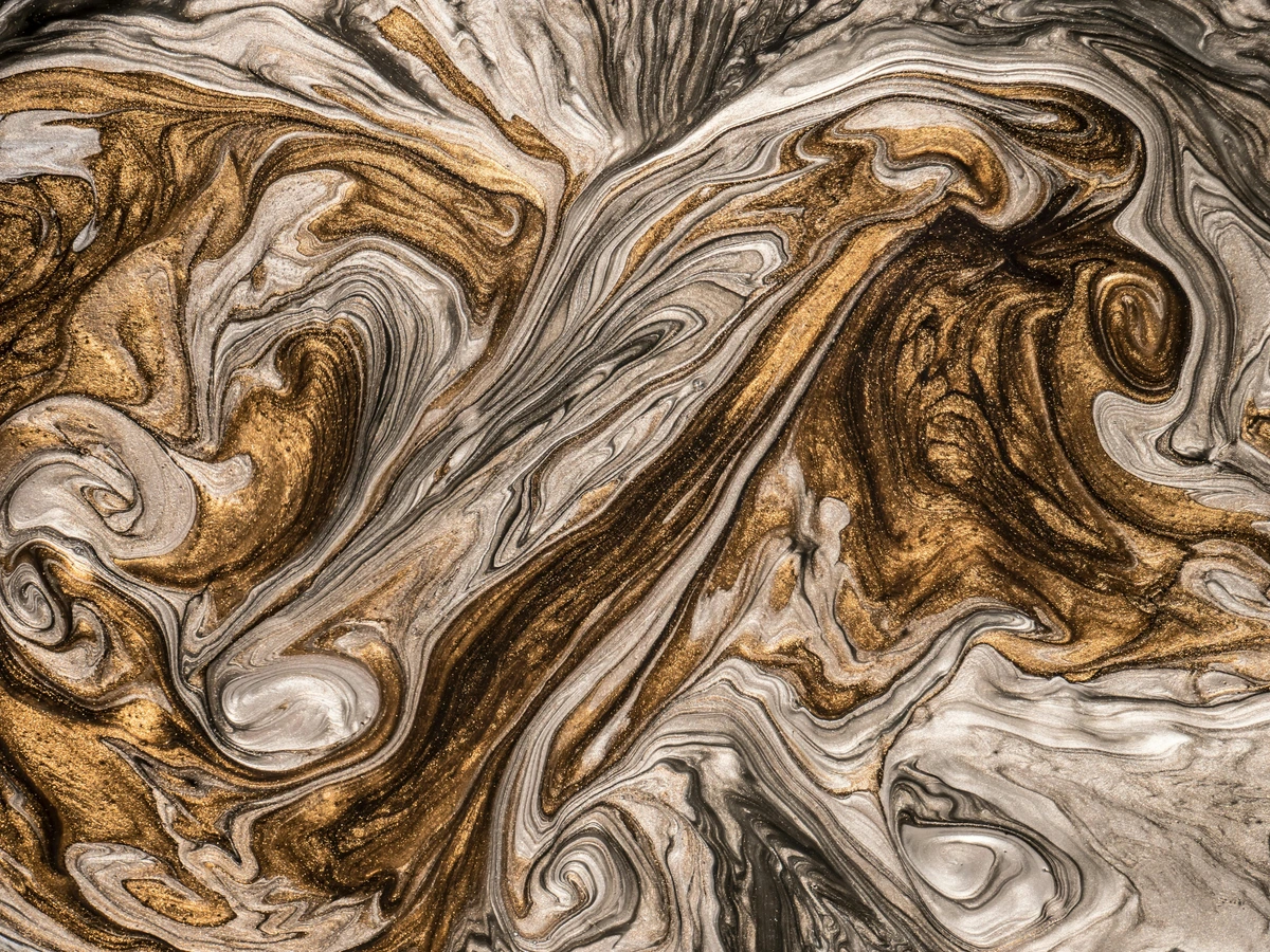 Close-up of an abstract painting with swirling gold and beige textures.