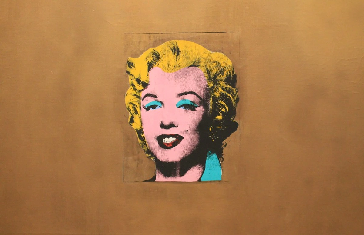 Iconic portrait of Marilyn Monroe as depicted by Andy Warhol using screen printing and gouache, housed in the Museum of Modern Art (MoMA). A celebrated example of Pop Art from 1962 with bold, contrasting colors and cultural significance.