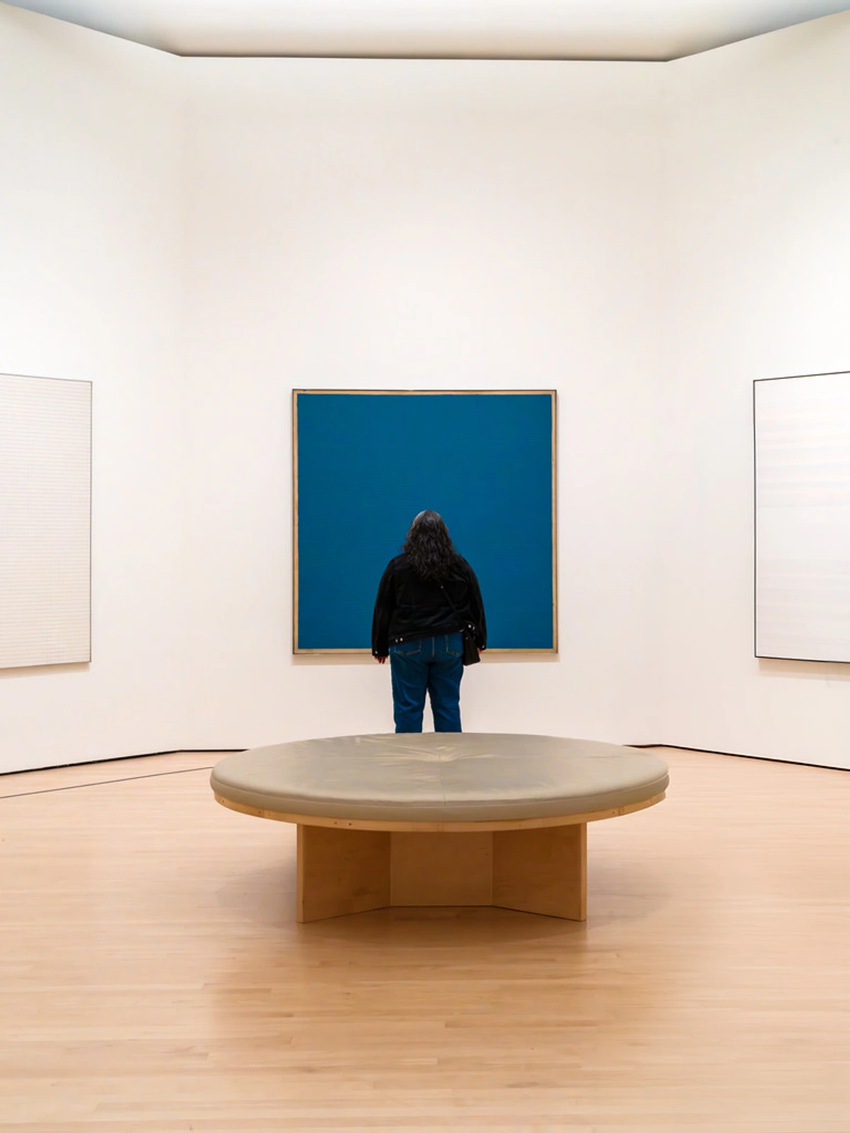 SFMOMA visitor engaging with minimalist blue panel artwork, fostering intellectual curiosity through modern art appreciation and interactive gallery experiences.