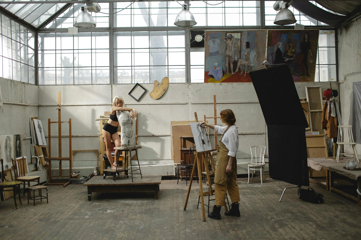 Artist drawing a nude model for technical art mastery study session in art studio environment with professional lighting and raw materials demonstration