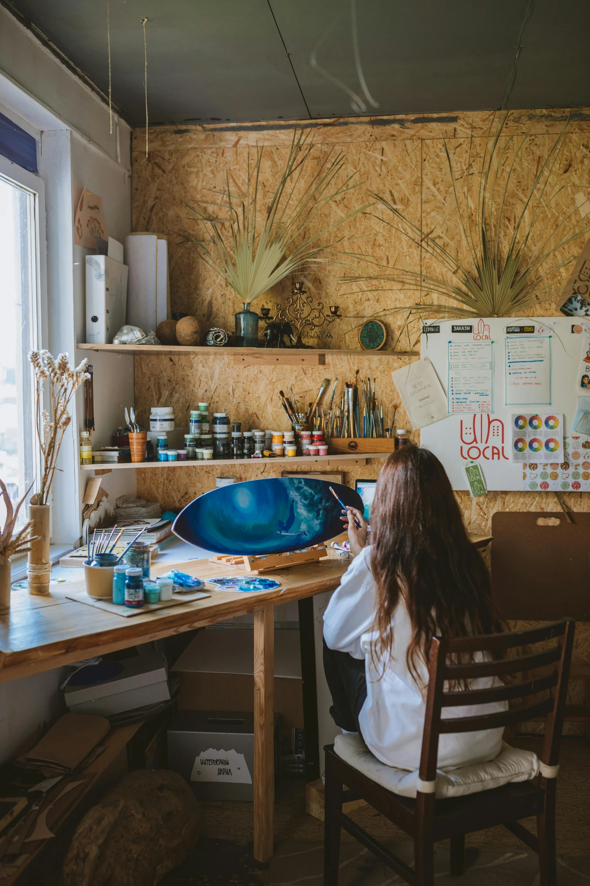 Woman developing technical mastery in art while painting at an organized workspace