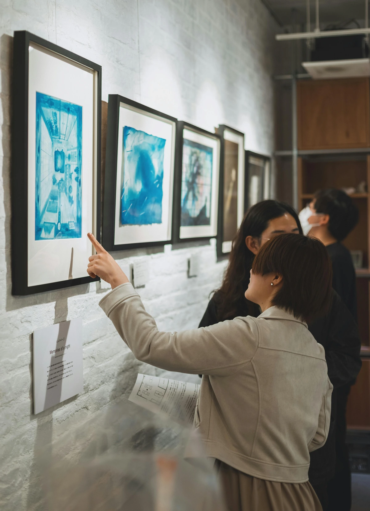 Visitors engaging with abstract art at Shinjuku Gallery, exploring conceptual creativity
