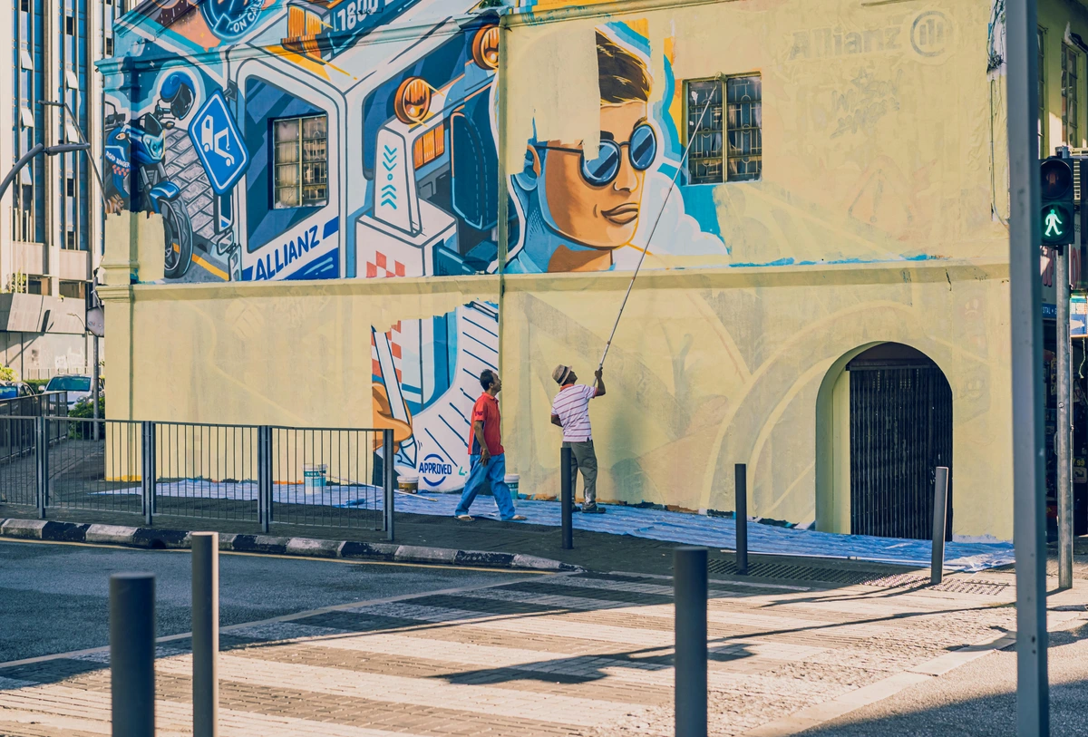 A man creating street art mural with vibrant colors on city wall