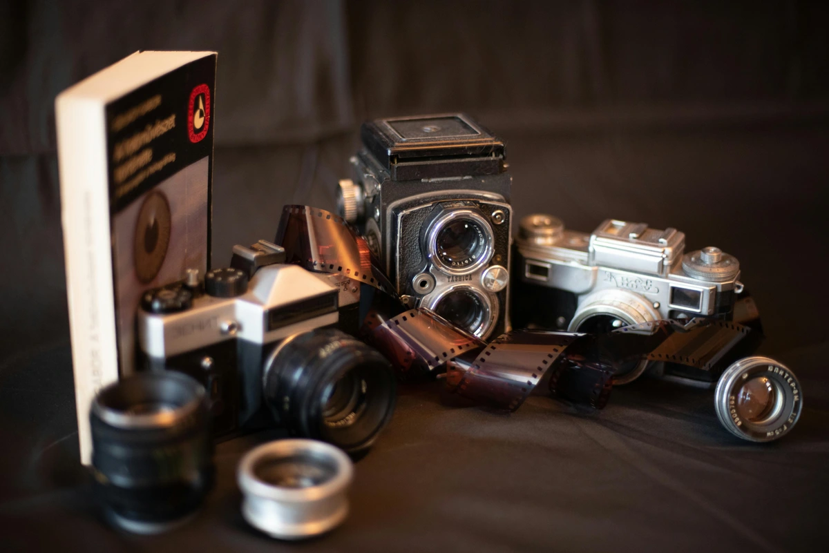 Close-up of vintage cameras and film rolls, essential equipment for art photography.