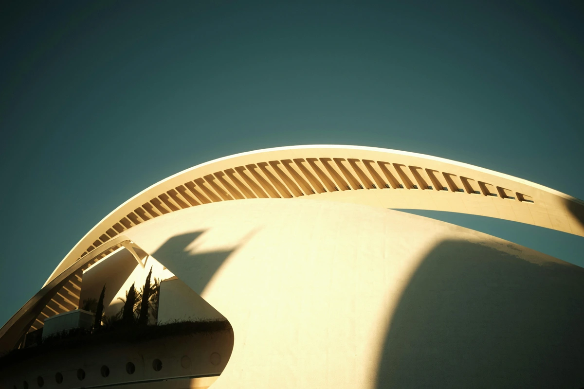Sun rising over the top of a building with a sun-shaped light installation and surrounding trees - Free Stock Photo. Architectural design by James Turrell.