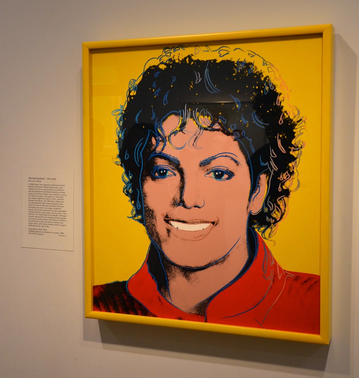 Andy Warhol's iconic pop art portrait of Michael Jackson, featuring his signature curly hair and a vibrant yellow background.