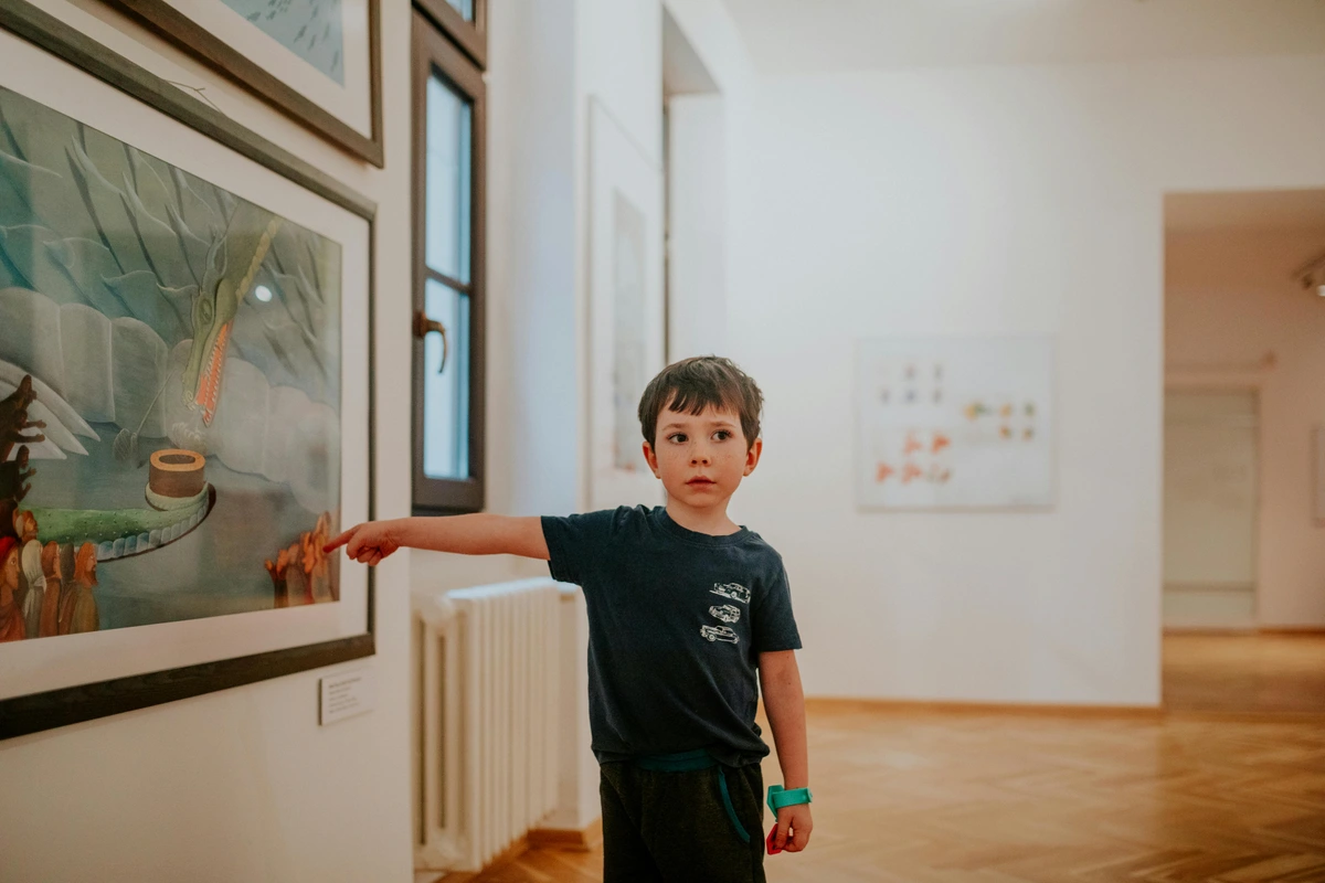 Young boy pointing at artwork in a gallery during exhibition visit