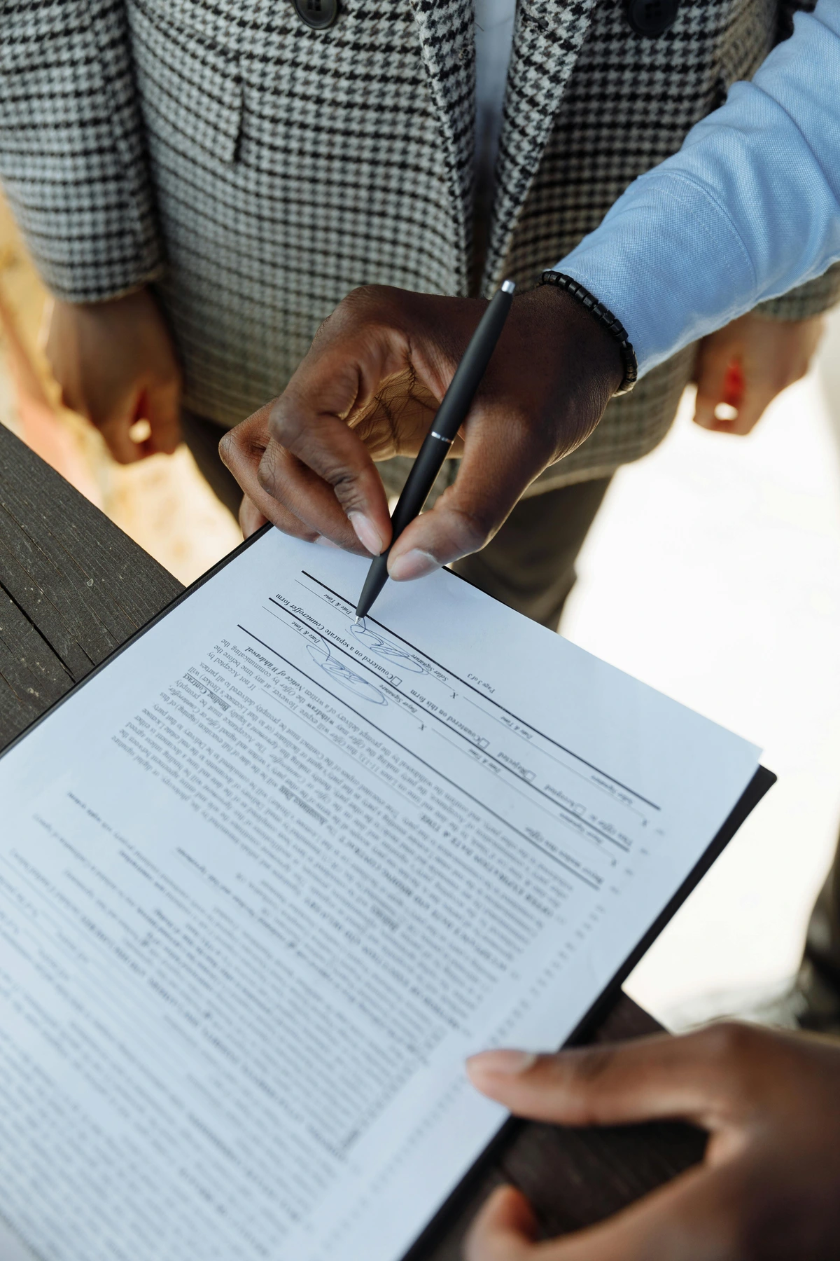 Person signing contract for art commission during business meeting