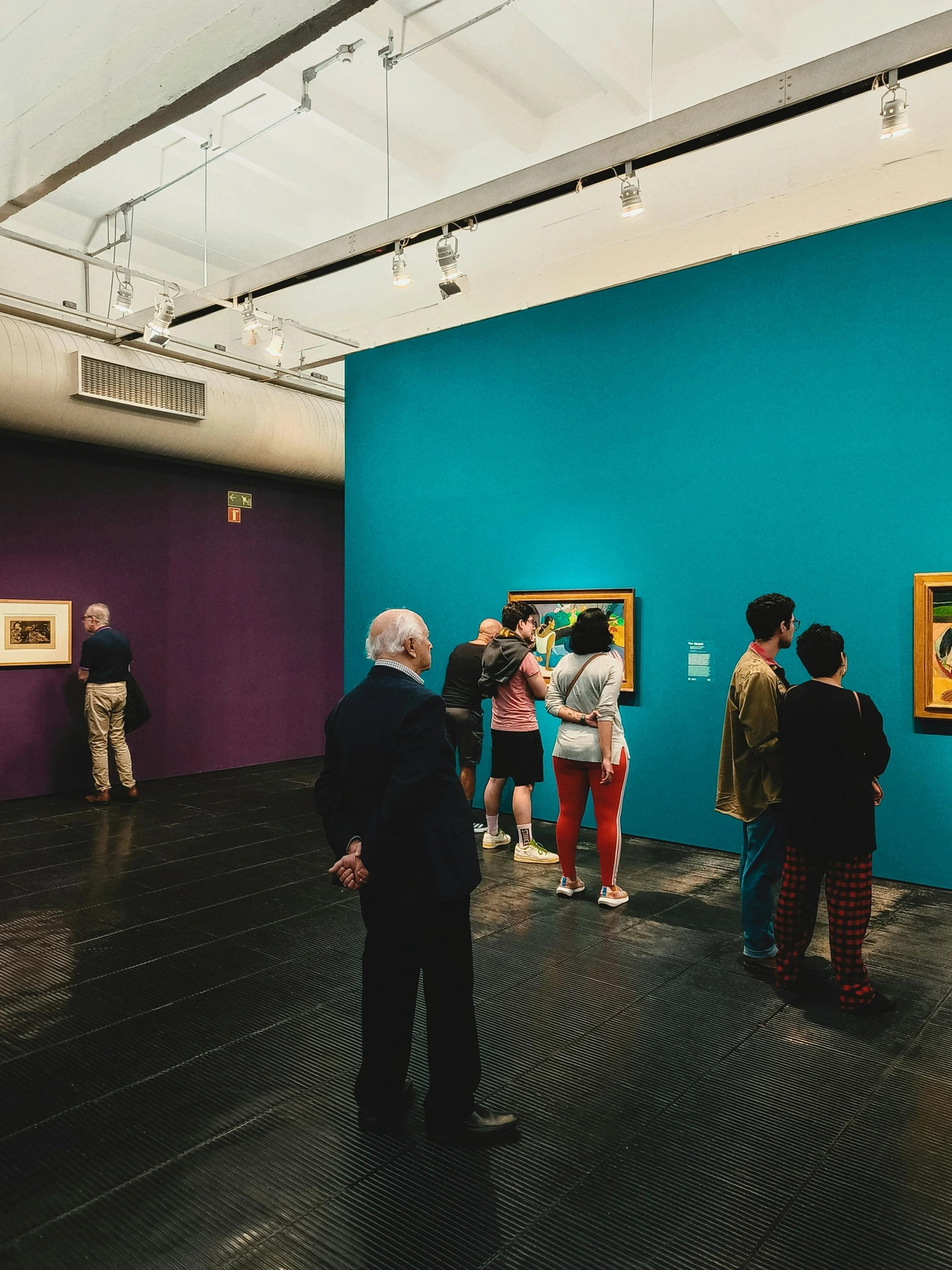 Visitors analyzing paintings in an art gallery for insights