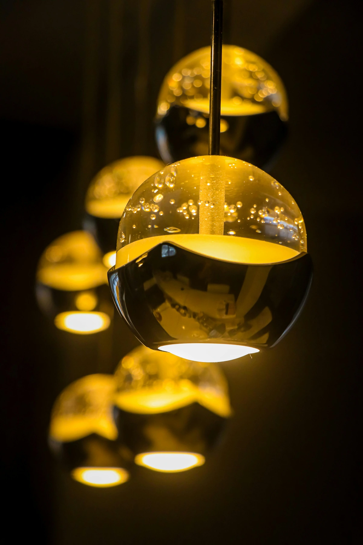 Elegant hanging decorative lamps with a warm, ambient glow, featuring glass shades with bubble details.