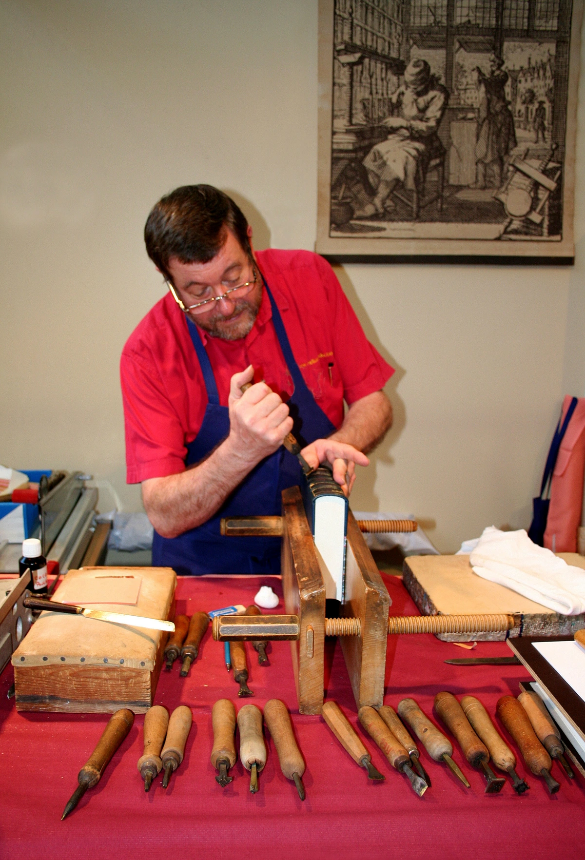 Bookbinder using tools to create a handmade sketchbook in a workshop