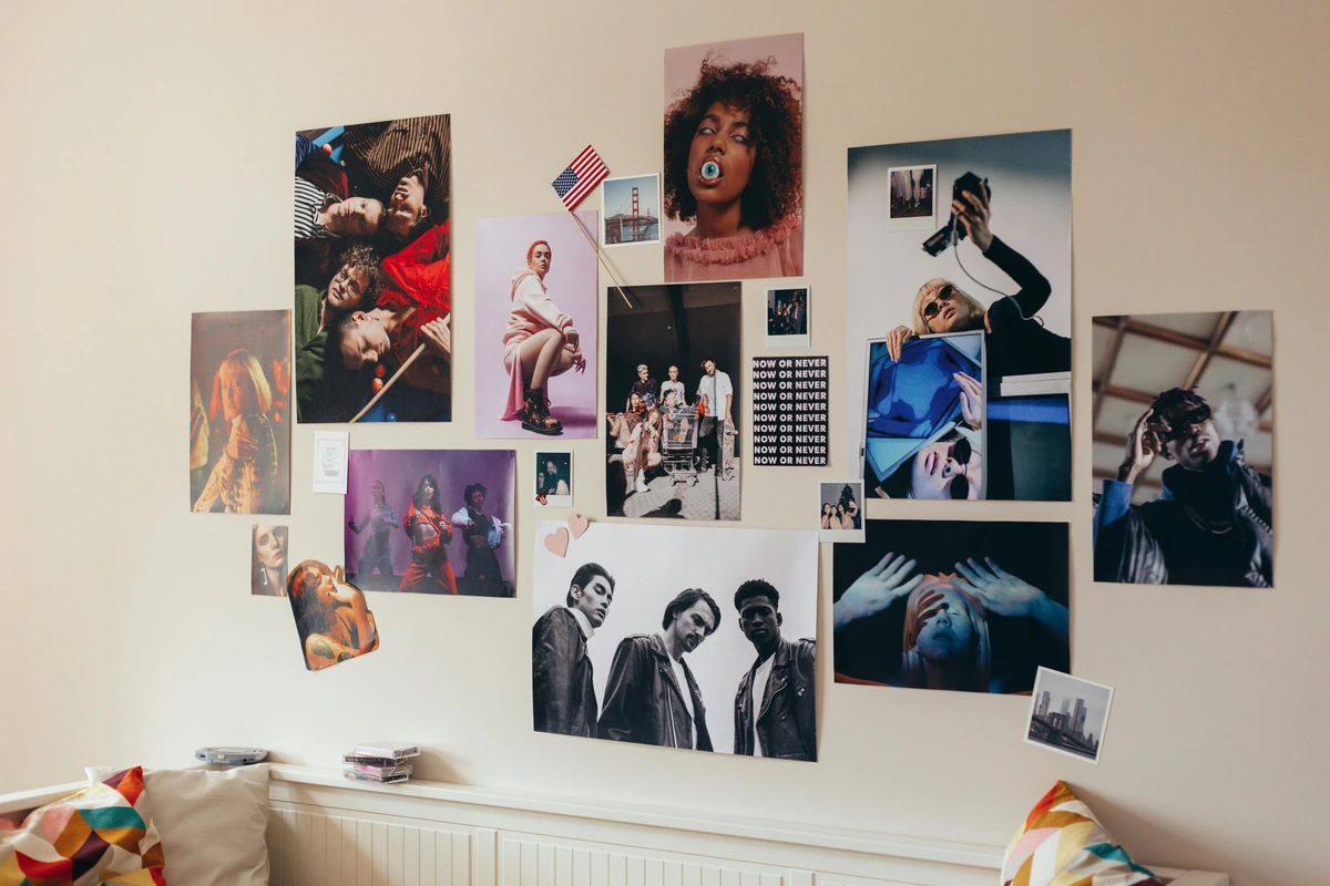 A wall adorned with a diverse collection of posters and photographs, creating a vibrant gallery wall.
