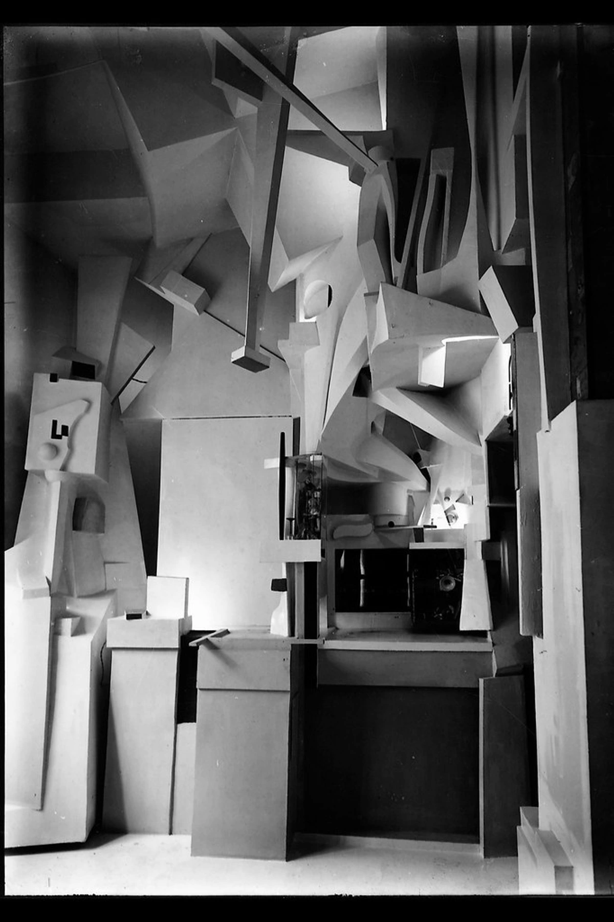 Kurt Schwitters Merzbau Collage Sculpture: Fragmented geometry and text elements in black and white conceptual art installation with irregular sculptural forms.