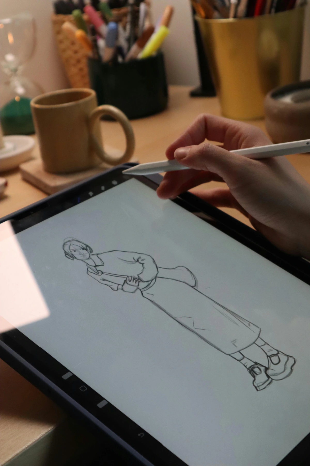 Person sketching a portrait on a digital tablet in a cozy workspace, demonstrating beginner-friendly art techniques for digital artists.