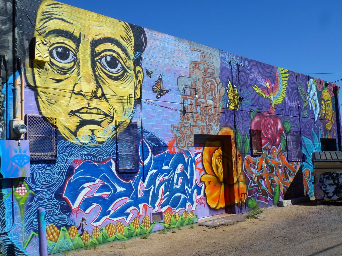 Vibrant Mexican mural by David Alfaro Siqueiros, part of 'Los Tres Grandes' series, depicting expressive faces and symbolic imagery.