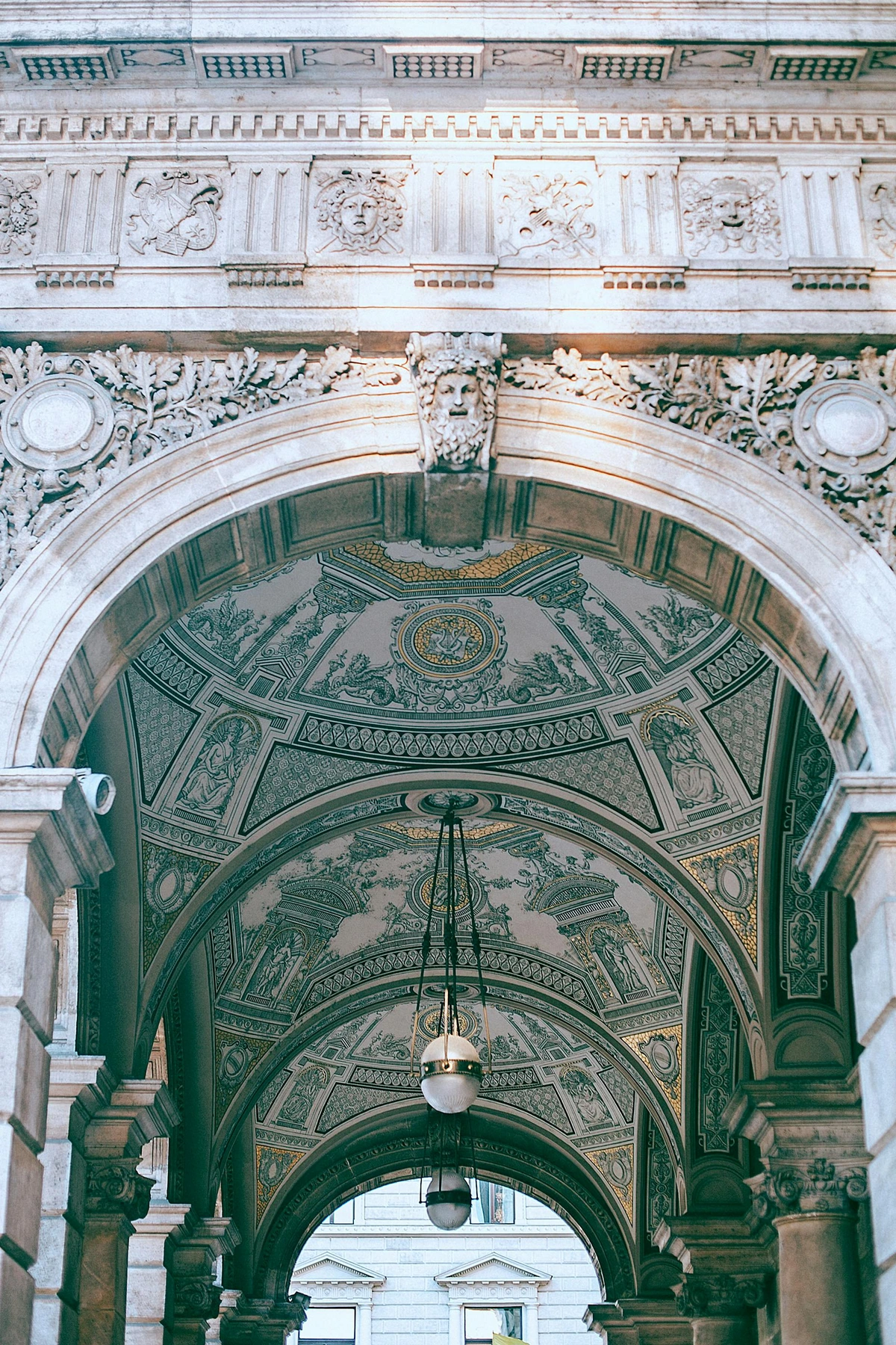 Richly decorated arch entrance of Palazzo Vecchio with decorative lamps and columns