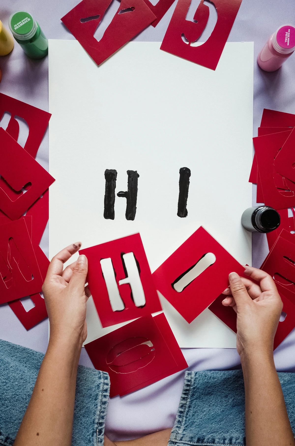 Create 'Hi' with red paper stencils on white paper – free stock photo