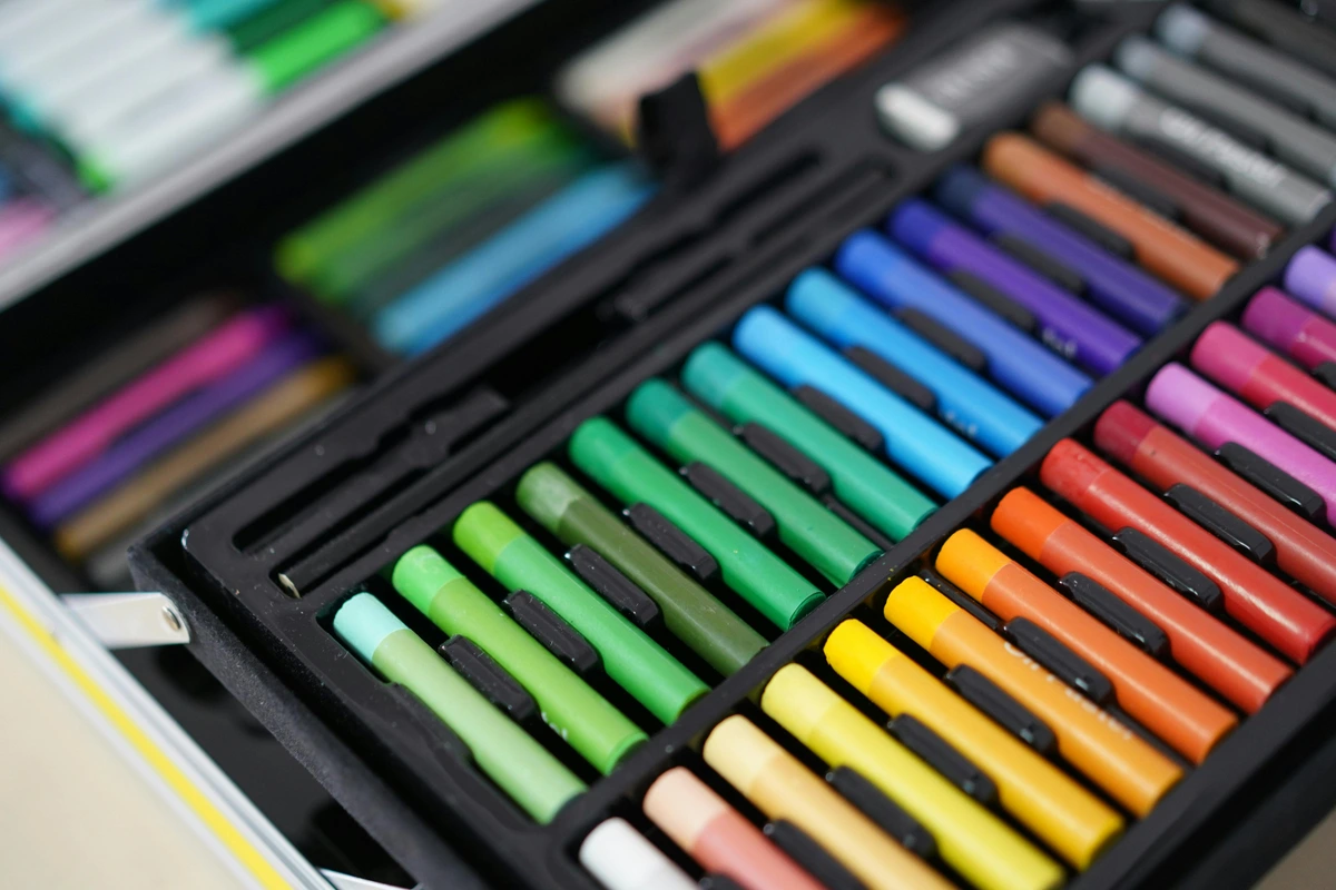 A close-up view of a set of colorful soft pastels arranged neatly in a black art box, ready for professional artists.