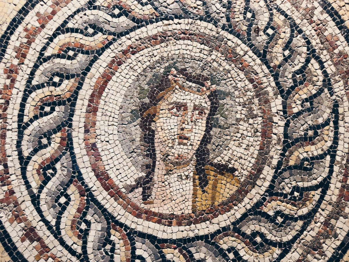 Close-up of an ancient mosaic portrait, showcasing intricate details and historical artistry.