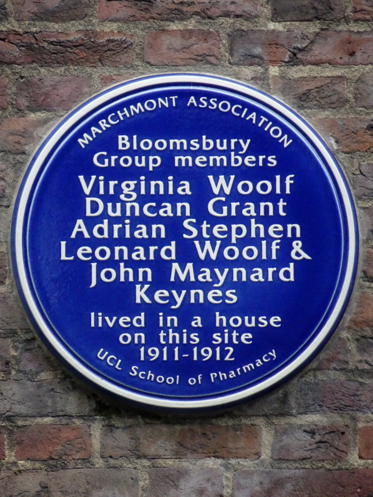 Blue plaque commemorating Bloomsbury Group members Virginia Woolf, Duncan Grant, Adrian Stephen, Leonard Woolf, and John Maynard Keynes, who lived in this house from 1911-1912, located at the UCL School of Pharmacy.