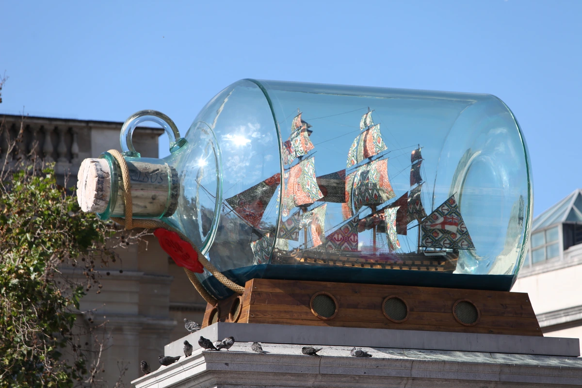 Nelson's Ship in a Bottle by Yinka Shonibare, a contemporary art installation featuring a model ship with vibrant, patterned fabric sails inside a large glass bottle.