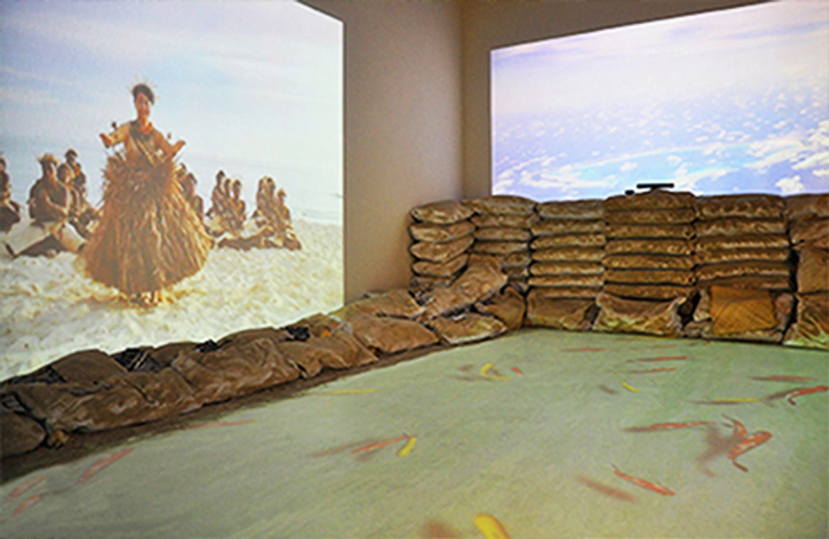Interactive installation at the 57th Venice Biennale featuring projected images of a traditional dance and clouds, with sandbags forming a barrier and koi fish projected on the floor.