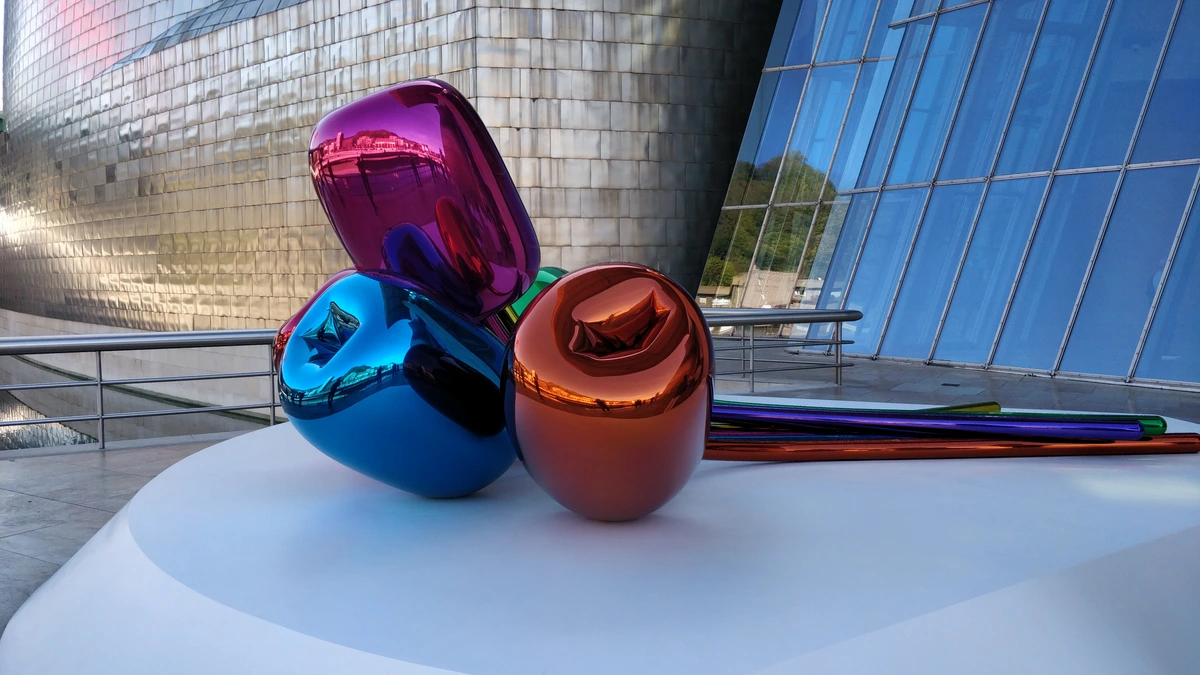 Jeff Koons' Tulips sculpture outside the Guggenheim Museum Bilbao, reflecting the building and surroundings.
