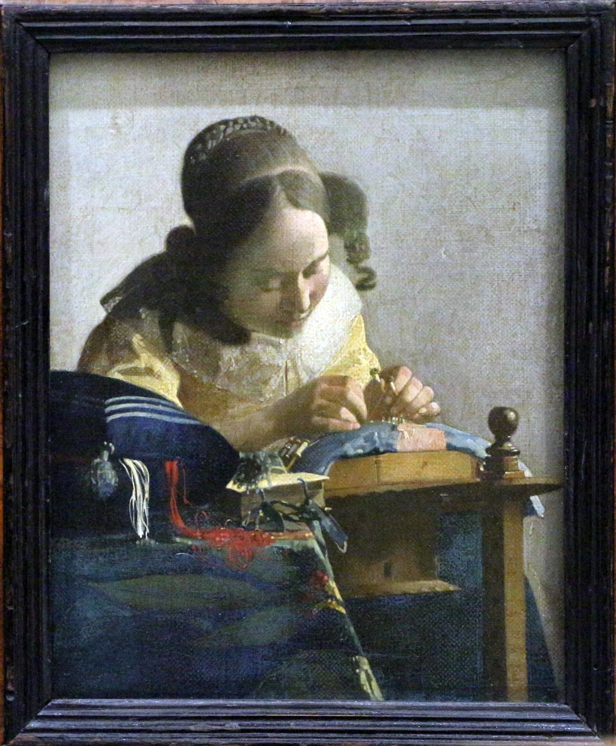 Johannes Vermeer's 'The Lacemaker' painting, showing a woman intently focused on making lace.