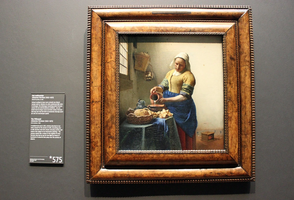 The Milkmaid by Johannes Vermeer, a famous Dutch Golden Age painting depicting a woman pouring milk.