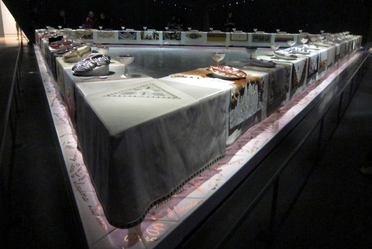 The Dinner Party installation by Judy Chicago at the Brooklyn Museum, featuring a triangular table with place settings for historical women.