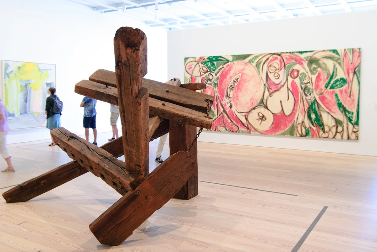 Lee Krasner abstract expressionist painting displayed at the Whitney Museum of American Art alongside a wooden sculpture.