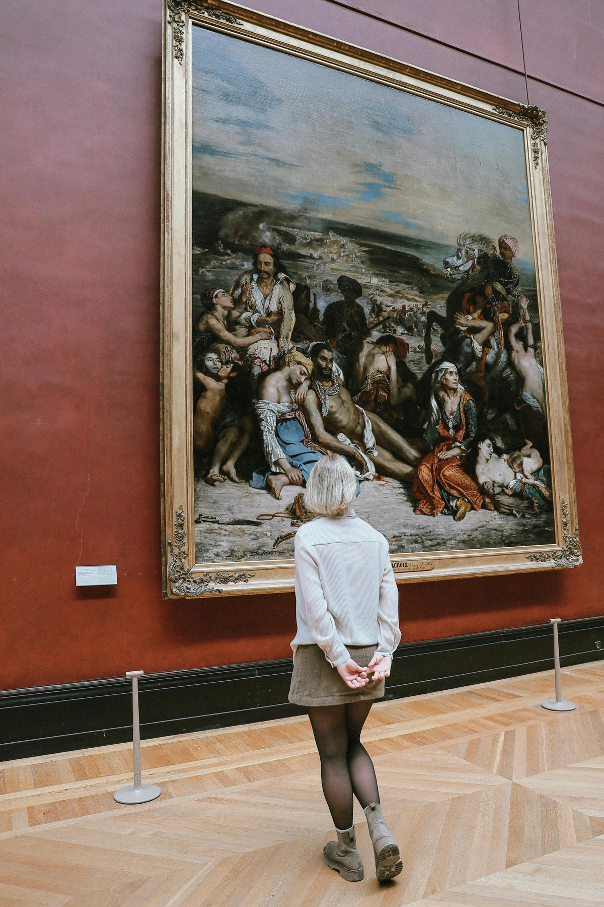 Woman examining classical artwork in a historic museum hall with protected art installations, ideal for cultural tourism resources and art institution tourism literature by free stockphoto collection sources OpenSpaces-USA-Nonprofit.org.
