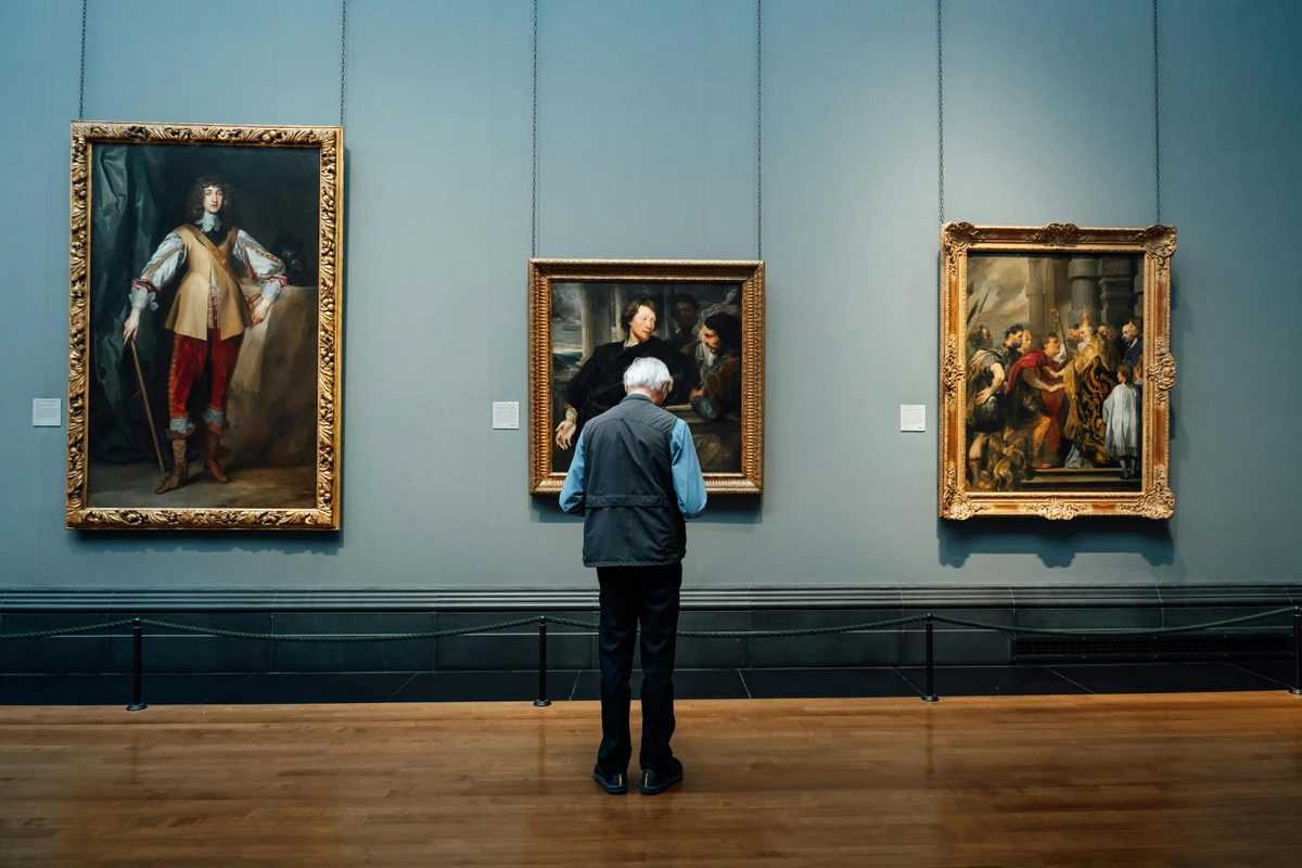 Art Enthusiast Observing Classic Paintings in a Gallery