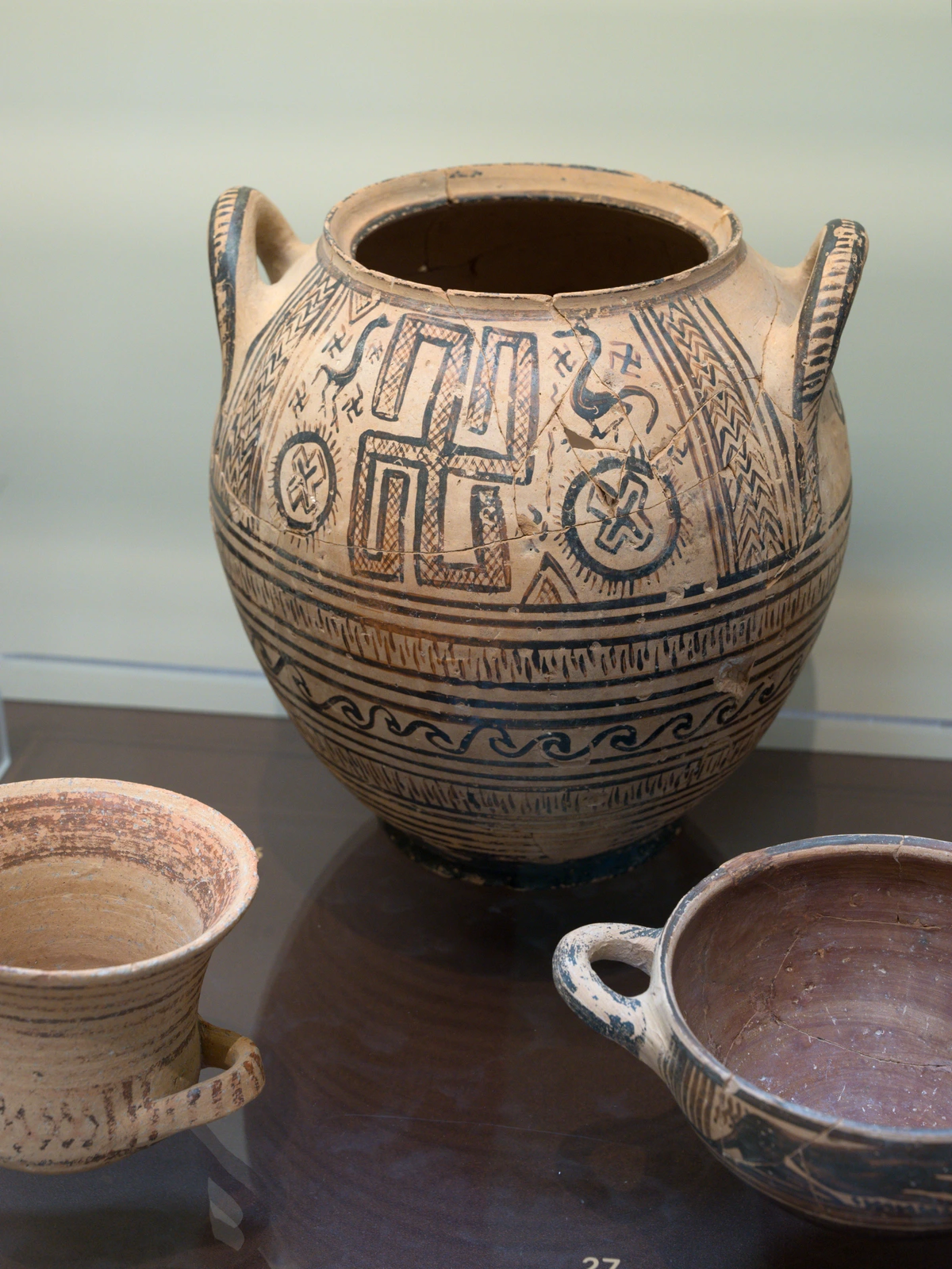 Boeotian Geometric period pottery krater with intricate black painted designs, displayed in the Archaeological Museum of Thebes.